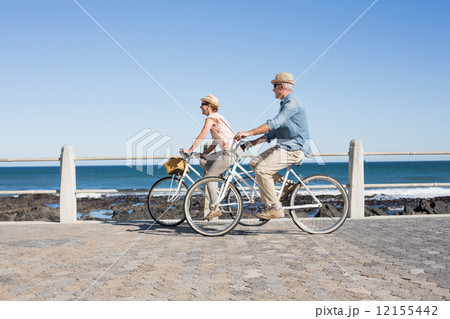Happy casual couple going for a bike ride on the pier 12155442