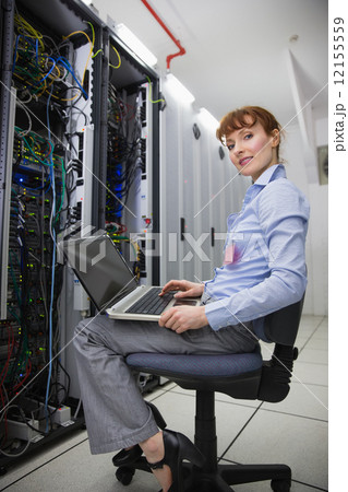 Happy technician sitting on swivel chair using laptop to diagnos Happy technician sitting on swivel chair using laptop to diagnos 12155559