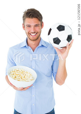 Handsome young man holding ball and popcorn Handsome young man holding ball and popcorn 12156566