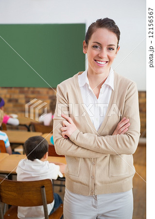 Pretty teacher smiling at camera at back of classroom 12156567