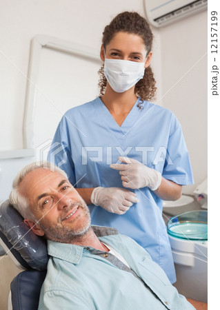 Patient and dentist smiling at camera 12157199