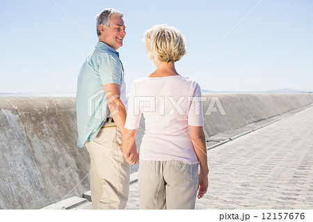 Senior couple holding hands and walking Senior couple holding hands and walking 12157676