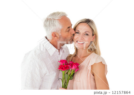 Affectionate man kissing his wife on the cheek with roses 12157864