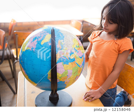 Cute little pupil looking at globe in classroom Cute little pupil looking at globe in classroom 12158046