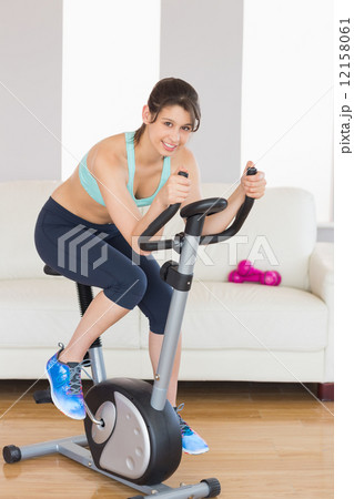 Fit brunette working out on exercise bike Fit brunette working out on exercise bike 12158061