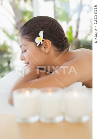 Beautiful brunette relaxing on massage table with salt scrub on Beautiful brunette relaxing on massage table with salt scrub on 12158116