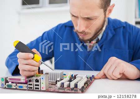 Computer engineer working on cpu with screwdriver Computer engineer working on cpu with screwdriver 12158278