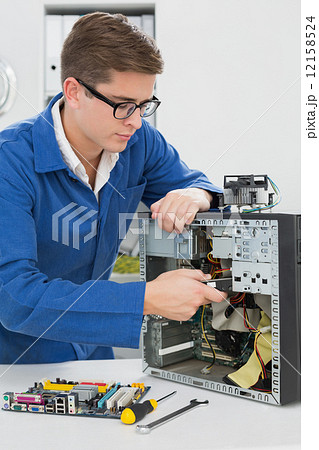 Young technician working on broken computer Young technician working on broken computer 12158524