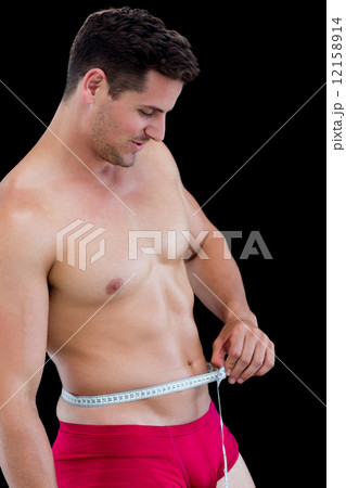 Side view of fit man measuring waist 12158914