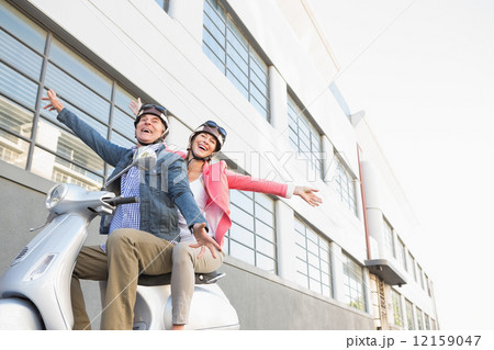 Happy senior couple riding a moped Happy senior couple riding a moped 12159047