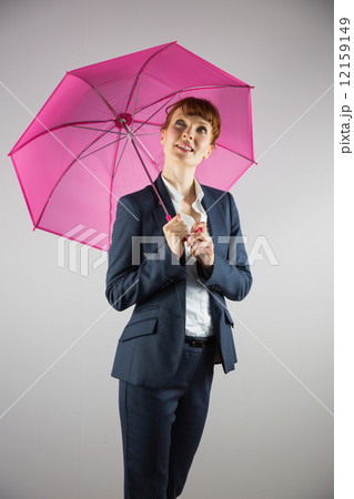 Smiling businesswoman holding pink umbrella 12159149