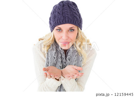 Pretty blonde in winter fashion blowing over hands 12159445
