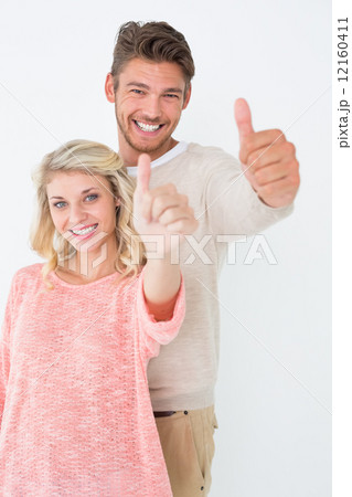 Happy young couple gesturing thumbs up 12160411