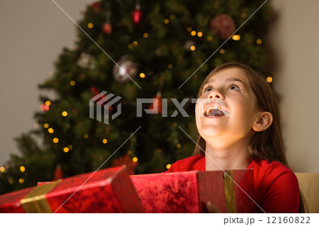 Little girl opening a magical christmas gift Little girl opening a magical christmas gift 12160822
