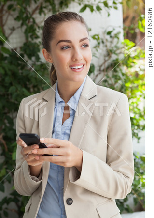 Beautiful businesswoman texting on phone 12160986