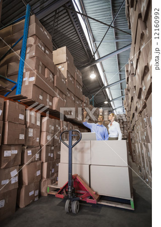Warehouse team working together with trolley 12160992