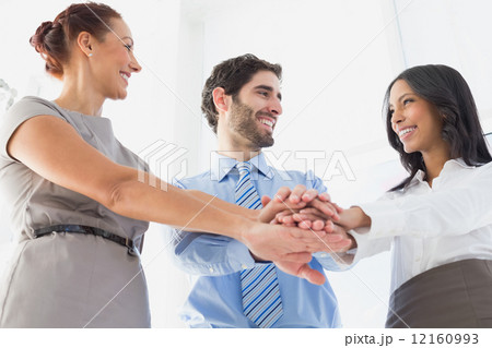 Workers with stacked hands smiling 12160993
