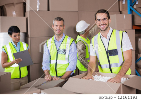 Warehouse workers in yellow vests preparing a shipment 12161193