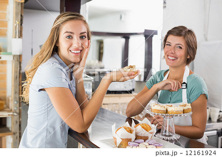 Pretty waitress serving cupcake to customer 12161924