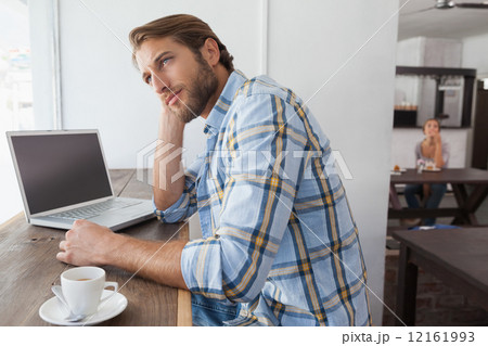 Casual man using laptop having coffee 12161993