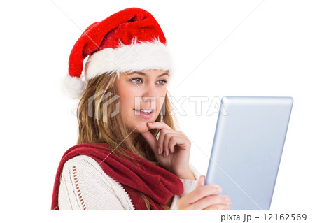 Festive blonde looking at tablet pc 12162569