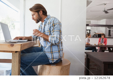 Casual man using laptop drinking espresso 12162678