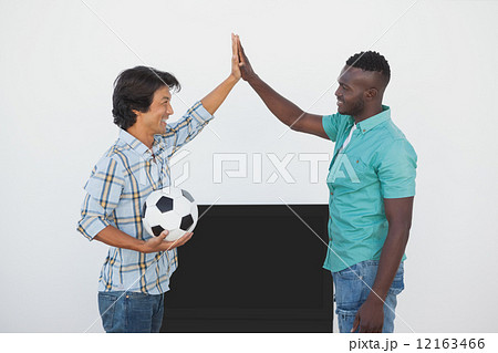 Soccer fans high fiving while watching tv Soccer fans high fiving while watching tv 12163466
