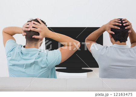 Two tensed soccer fans watching tv 12163475