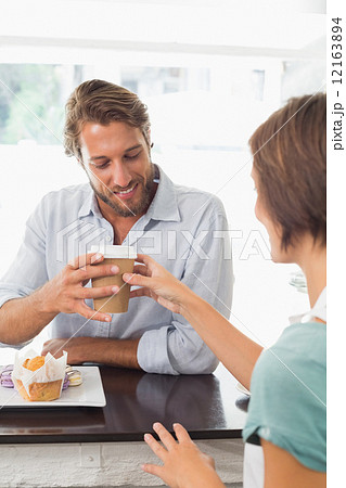 Pretty barista serving happy customer Pretty barista serving happy customer 12163894