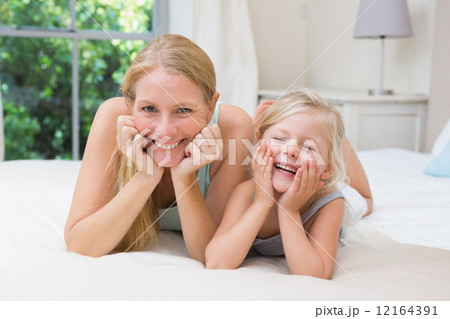 Cute little girl and mother on bed Cute little girl and mother on bed 12164391