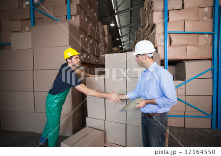 Warehouse worker loading up a pallet with manager Warehouse worker loading up a pallet with manager 12164550