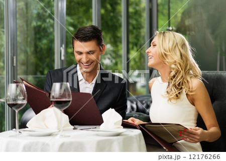 Cheerful couple with menu in a restaurant Cheerful couple with menu in a restaurant 12176266