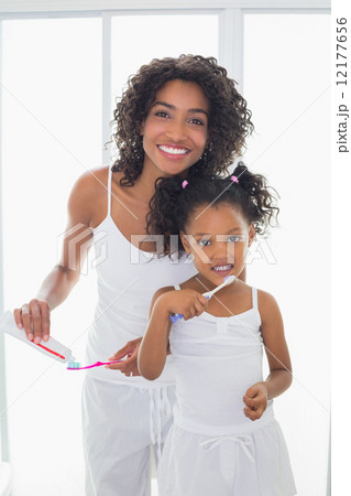 Pretty mother with her daughter brushing their teeth Pretty mother with her daughter brushing their teeth 12177656
