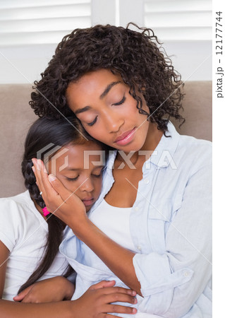Pretty mother sitting on the couch with her sleeping daughter Pretty mother sitting on the couch with her sleeping daughter 12177744
