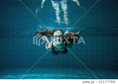 Athletic swimmer smiling at camera underwater 12177768