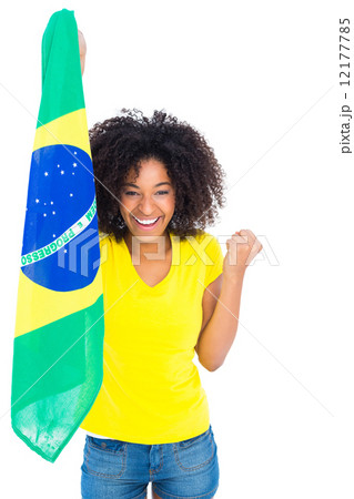 Pretty girl in yellow tshirt holding brazilian flag cheering at 12177785