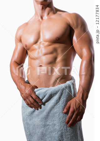 Mid section of a shirtless muscular man in white towel 12177834