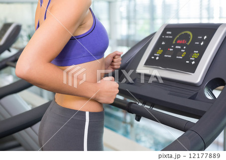 Fit woman running on the treadmill 12177889