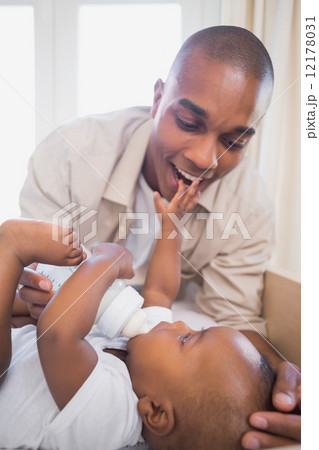 Happy father playing with his baby son in crib 12178031