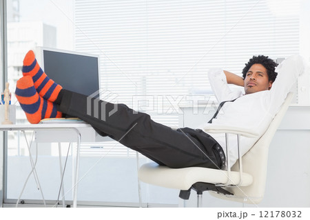 Businessman relaxing in his swivel chair with feet up Businessman relaxing in his swivel chair with feet up 12178032
