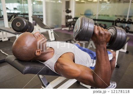 Muscular man exercising with dumbbells Muscular man exercising with dumbbells 12178118