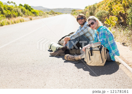 Attractive couple sitting on the road waiting for a lift 12178161