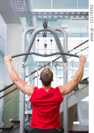 Strong man using weights machine for arms Strong man using weights machine for arms 12178162