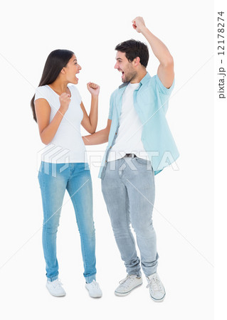 Happy casual couple cheering together 12178274