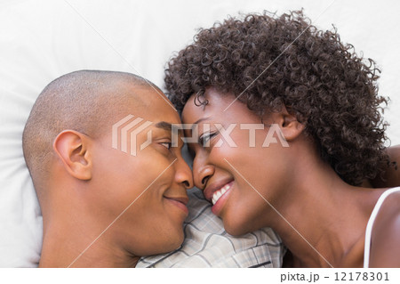 Happy couple lying in bed together 12178301