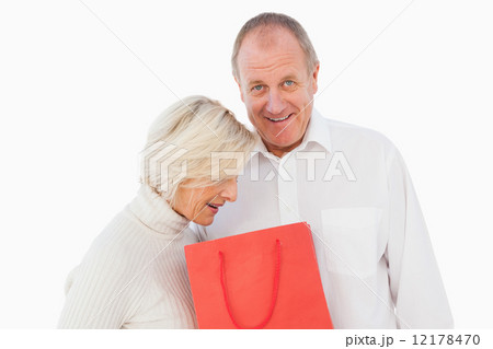 Older couple holding red gift bag Older couple holding red gift bag 12178470
