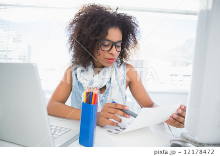 Pretty photo editor working at her desk Pretty photo editor working at her desk 12178472