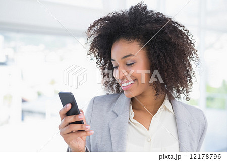 Casual businesswoman texting on phone Casual businesswoman texting on phone 12178796