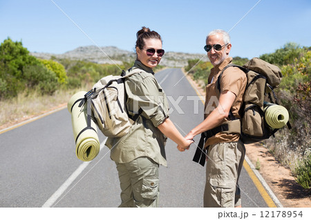 Hitch hiking couple standing holding hands on the road Hitch hiking couple standing holding hands on the road 12178954