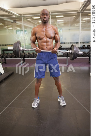 Muscular man lifting barbell in gym Muscular man lifting barbell in gym 12178960